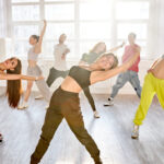group of trendy caucasian teenagers dancing hip-hop in studio